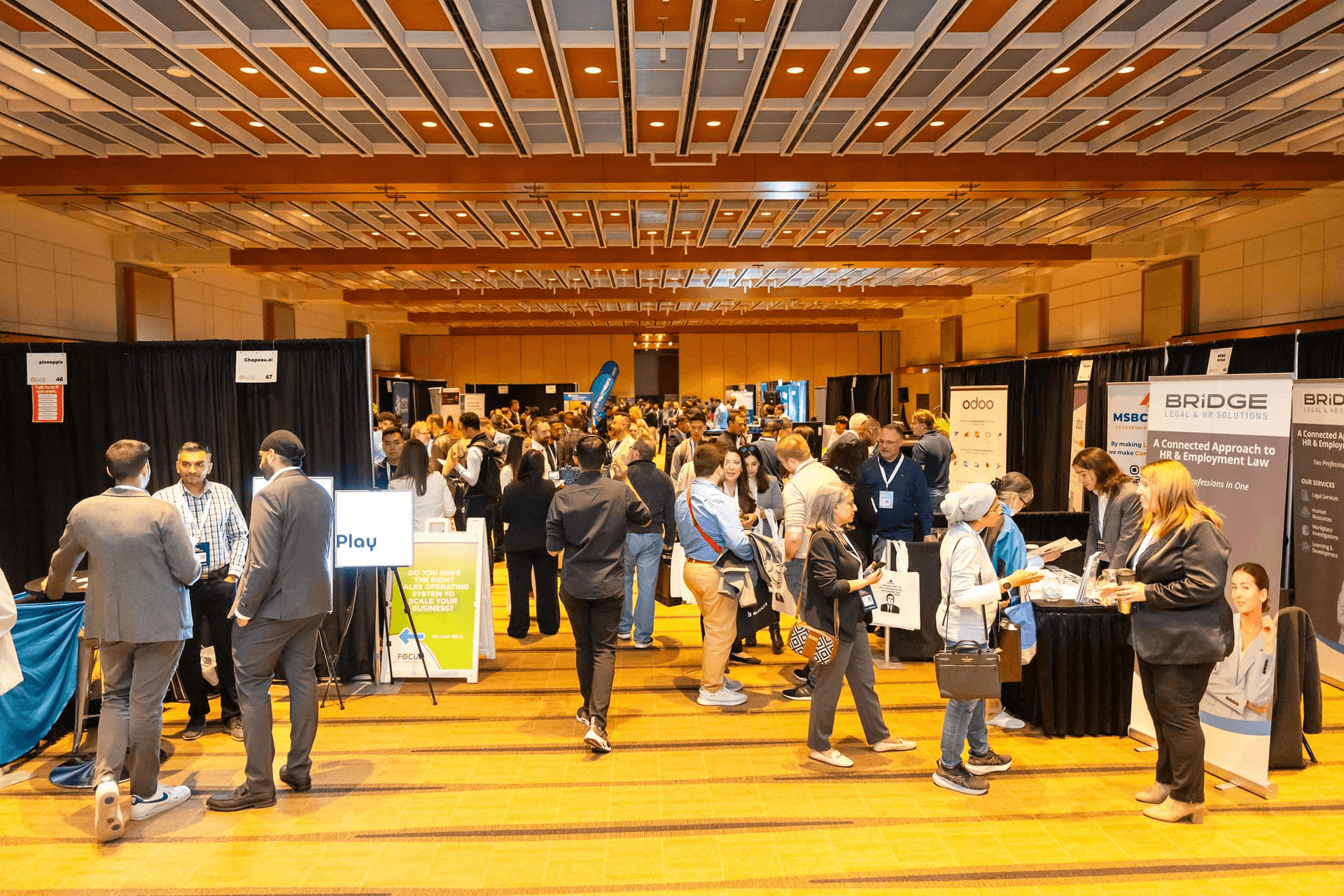 Crowded exhibitor hall with attendees visiting booths